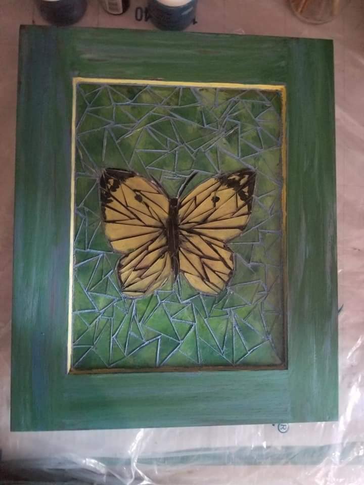 Mockzaick of yellow butterfly with green background and green wooden frame frame.